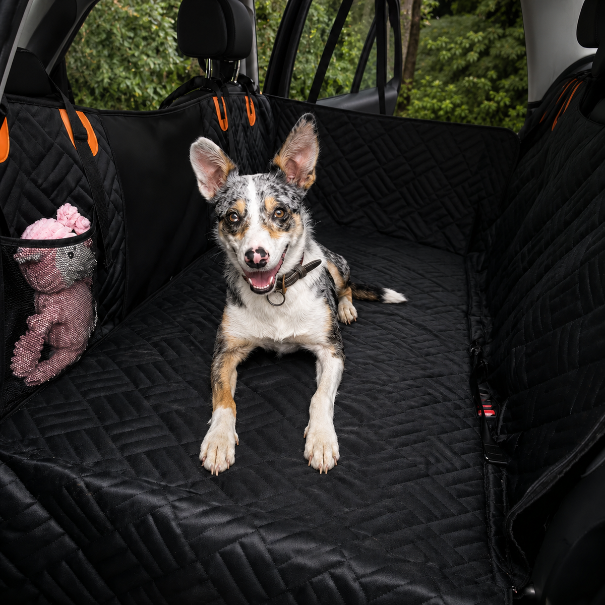 Happy dog sitting on the Peptiq CleanRide quilted back-seat car cover